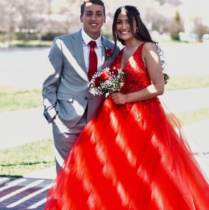 Сouple wearing a red gown and a gray suit